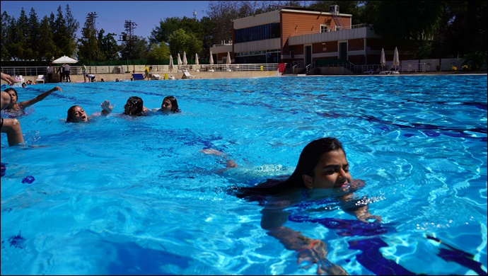 Kız çocukları olimpik havuzda yüzme öğreniyor